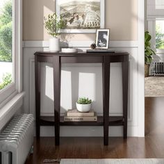 a small table with a plant on it in front of a window and a radiator