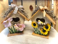 two bird houses with sunflowers and other flowers