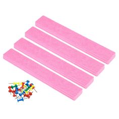 three pieces of pink foam with colorful pins