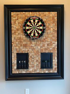 a dart board mounted to the side of a wall next to two electrical plugs