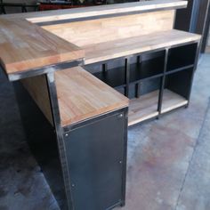 a kitchen island made out of metal and wood with an open shelf on the side