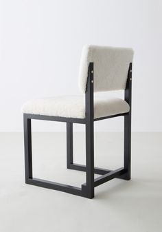 a white chair with black frame and upholstered seat, against a white background