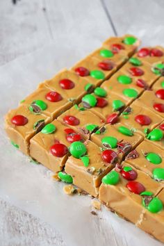 some kind of candy bar on top of a piece of parchment paper with m & m candies