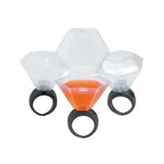 three clear and orange vases sitting on top of each other with rings around them