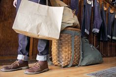 a person holding a brown bag and some shoes