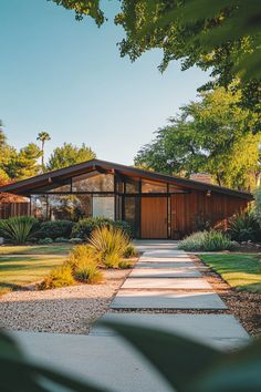 a house with a walkway leading to the front door and side entrance that is surrounded by trees