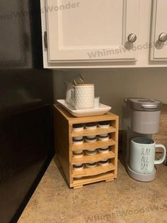 a coffee mug sits on a wooden stand next to a cup holder with cups in it