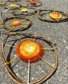 several circular objects are on the ground with sticks and yarn around them that have been placed together