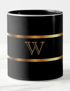 a black and gold coffee mug with the letter w on it