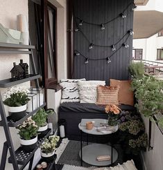 a small balcony with potted plants and other things on the table, along with a ladder