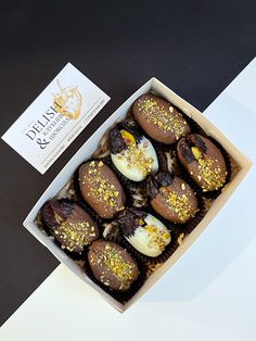 a box filled with chocolate covered desserts next to a business card on a table