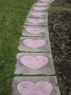 three cement hearts painted on the sidewalk