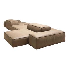 a brown and beige sectional couch sitting on top of a white floor