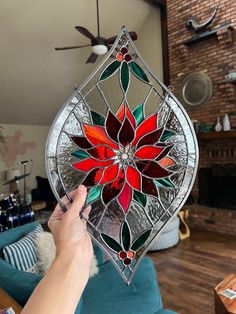 a person holding up a stained glass flower