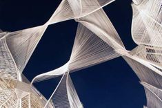 an artistic sculpture is shown against the blue sky in this photo, it looks like white fabric