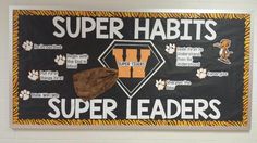 a bulletin board with the words, super habitats and paw prints on it in front of a white brick wall