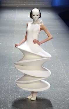 a woman in a white dress on a runway