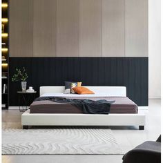 a modern bedroom with black and white walls, wood paneling, and a large bed