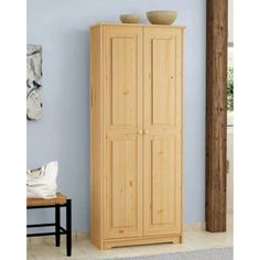 a tall wooden cabinet with two bowls on top