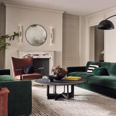 a living room filled with green couches and chairs next to a fire place in a fireplace