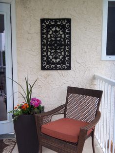 a brown chair sitting on top of a patio next to a planter filled with flowers