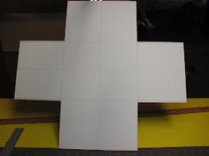 a cross made out of white paper sitting on top of a table