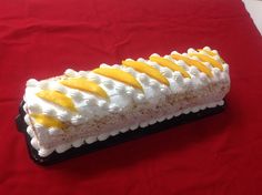 a piece of cake with yellow and white icing sitting on a red table cloth