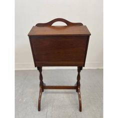 an old wooden table with a handle on it's top and legs that are bent to the side