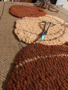 three pieces of knitted material are laying on a bed with a person in the background