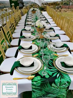 a long table is set with white plates and green napkins