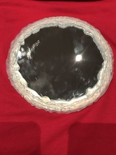 a black and white bowl sitting on top of a red table cloth