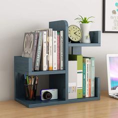 a laptop computer sitting on top of a wooden desk next to a bookshelf