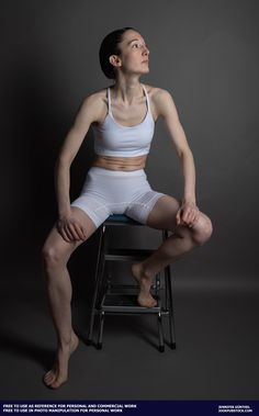 a woman sitting on top of a chair with her legs crossed in front of her face