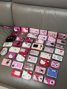 many different types of hello kitty cameras on a couch with a chain attached to it