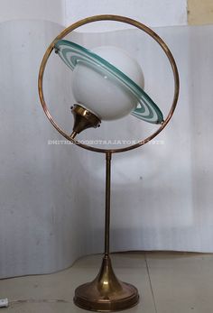 an antique globe on a metal stand with a white ball and green stripe around it