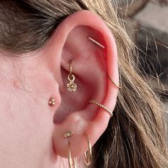 a close up of a person's ear with three different types of piercings