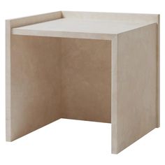 the corner table is made out of concrete and has a white finish on it's surface