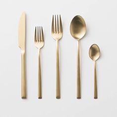 four forks, two spoons and one knife on a white surface