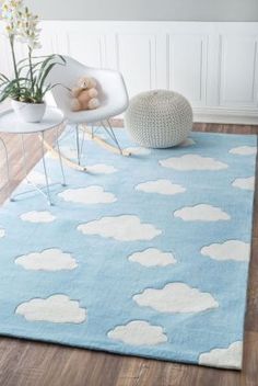 a blue rug with white clouds on it and a teddy bear sitting in the chair