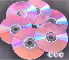 six cd's sitting on top of each other in front of a black background