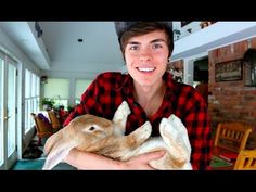 a young man holding a rabbit in his arms