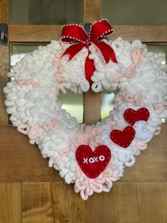 a valentine's day wreath hanging on the front door