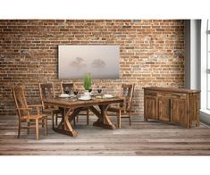 a dining room table with chairs and a sideboard in front of a brick wall