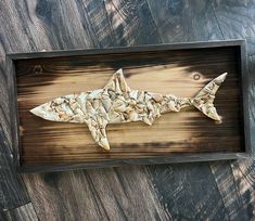 a fish made out of wood sitting on top of a wooden table