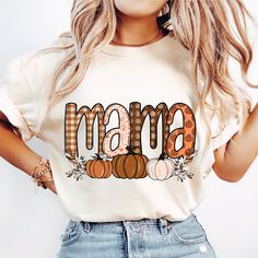 a woman wearing a white shirt with the word mama written in pumpkins on it