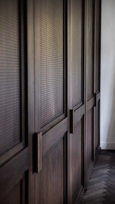 an empty room with wooden doors and hard wood flooring