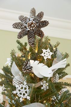 a small christmas tree decorated with pine cones and snowflakes