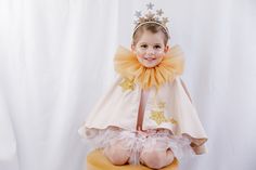 This adorable capelet in caramel honey coloured pure cotton velvet with gold glitter star applique will make you little one the star of the show whether they are performing in the Christmas play or at their birthday party. Fully lined in eco-friendly Tencel and closing with a button. Matching tulle collars can be purchased separately. Please note the colour of the cape will be the honey caramel shown in the detail pictures, not the one in the first listing picture. Winter Festival One-size Cape, Nativity Star Costume, Luxury Capelet For Costumes, Tinsel Cape, White Rabbit Costumes, Rabbit Costume, Gold Glitter Stars, Christmas Play, Glitter Stars