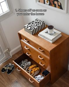 there is a shoe cabinet with shoes in it and an open drawer on the floor