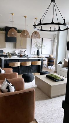 a living room filled with furniture next to a kitchen